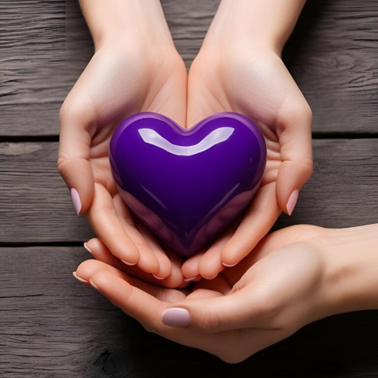 Des mains tenant un cœur violet (la couleur symbolique de la fibromyalgie).